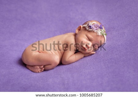 Sleeping newborn baby on a violet blanket