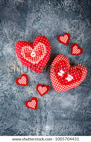 Two decorative handmade textile heart for Valentines day on grey concrete background