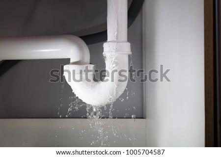 Close-up Of Water Is Leaking From The White Sink Pipe Royalty-Free Stock Photo #1005704587