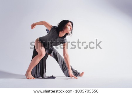 Modern contemporary dancer poses in front of the studio background. motion picture