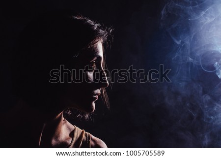 Modern contemporary dancer poses in front of the studio black background with the smoke. portrait view with copyspace closeup