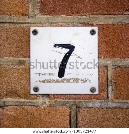 Weathered house number seven (7)