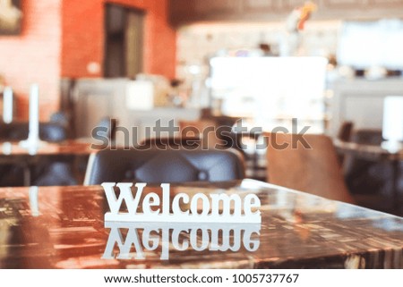 Welcome sign made by wood in white color on the table in coffee shop. 