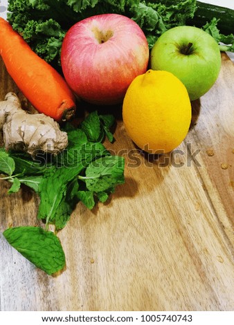organic raw ingredient for healthy food life style. fruit and vegetables on the wood table. carrot, apple, green apple, lemon, mint leaf, onion, vegetable.