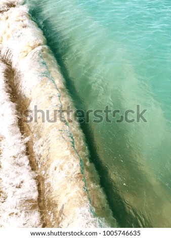 Colorful background with the Caribbean waves of the Aruba's Eagle Beach as they crash on the shore