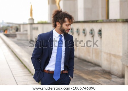 Attractive businessperson calling cooperator and disputing by phone with Eiffel Tower in background in. Young man making official journey to France. Concept of works debating and detached duty to