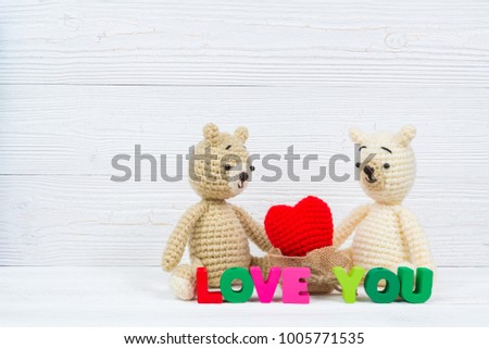 Sweet couple teddy bear doll in love with Love text and red knitting heart on white wooden background and copy space for add text and picture, love and valentine day concept idea.