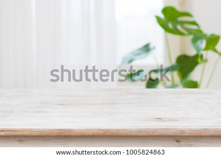 Concept of table for product display over defocused window background Royalty-Free Stock Photo #1005824863
