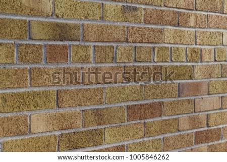 Traditional weathered brick wall background in varying shades of light brown, with American common bond brick layer pattern