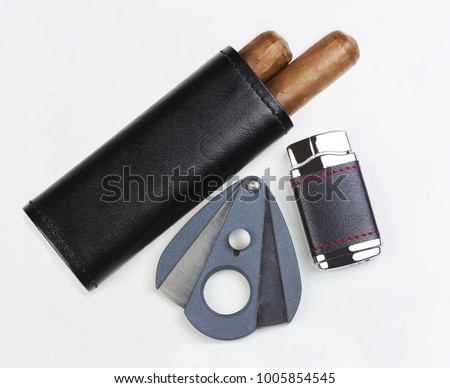 Black leather pouch with two Cuban cigars, cutter and lighter, isolated on white background Royalty-Free Stock Photo #1005854545