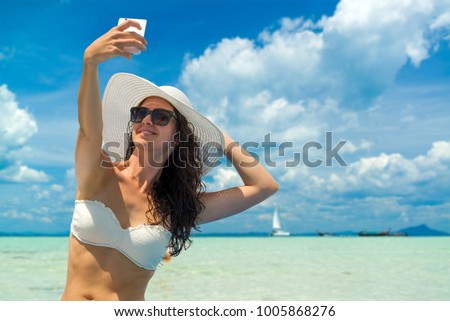 Beautiful Woman at the beach in Thailand taking a selfie photo