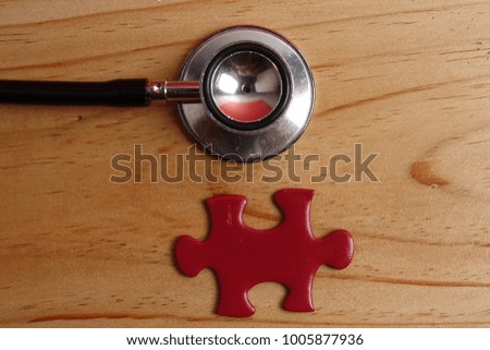 HEALTH CARE CONCEPT: Missing jigsaw puzzle and stethoscope on wooden table. Copy Space