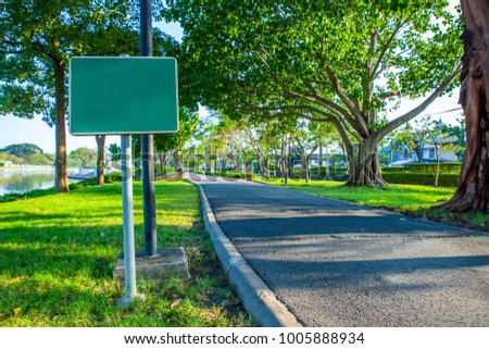 Blank sign on Road pathway Jogging track in the  public park under big tree