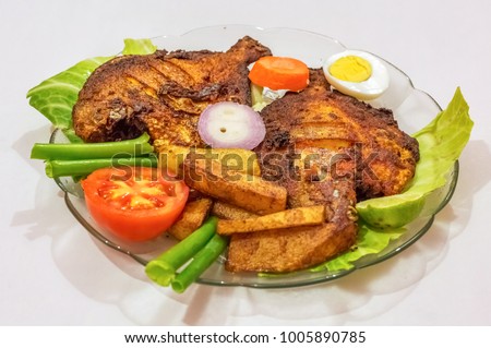 Crispy spicy fried pomfret fish with french fries and garnished with vegetables. A popular Bengali Indian cuisine. Royalty-Free Stock Photo #1005890785