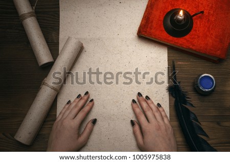 Female hand, blank paper page sheet with copy space and vintage books on wooden table background. Education concept. Back to school.