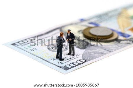 Businessmen miniature figurine macro photo. Cash money - USA banknote and coin. Business agreement profit. Successful business strategy. Market share growth by merge and acquisitions. Company budget