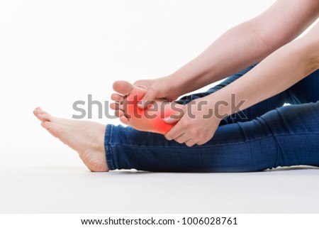 Pain in woman's legs, massage of female feet on white background, studio shot
