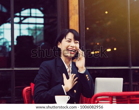 Happy young business Asian woman using laptop in coffee shop.