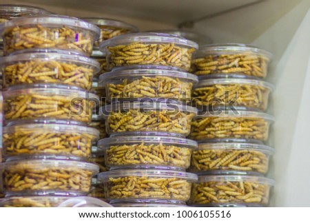 Fried bamboo worms packing in the market for sale. Bamboo caterpillar (Omphisa Fuscidentalis), fried bamboo worms that ready to eat and for souvenir. Royalty-Free Stock Photo #1006105516