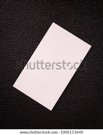 Blank card on dark texture background. White contact card for your design.