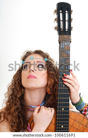 Beautiful woman holding her old guitar in hippie outfit on white background isolated