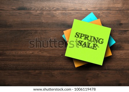Spring Sale, the phrase is written on multi-colored stickers, on a brown wooden background. Business concept, strategy, plan, planning.