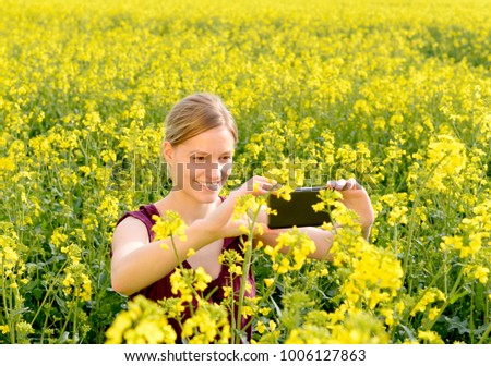  happy young woman with smartphone  in the rape field