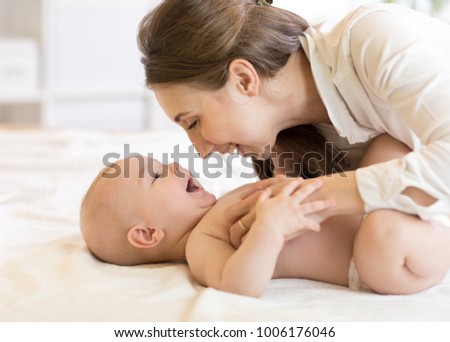 Portrait of mom and baby laughing and playing