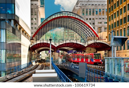 Train leaves Canary Wharf docklands station in London Royalty-Free Stock Photo #100619734