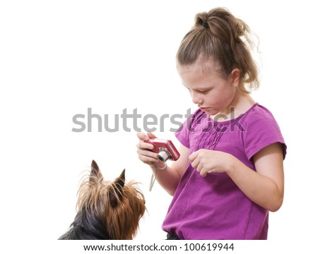 preteen girl taking photo of pet dog
