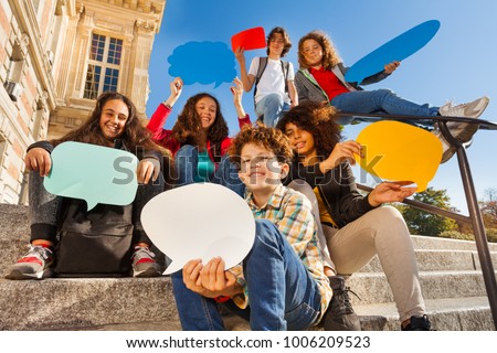 Smiling teenage boys and girls with speech bubbles