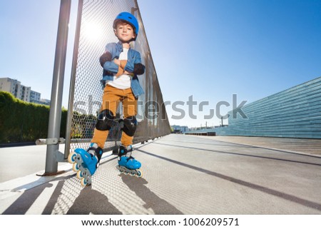 Young inline skater standing at outdoor rollerdrom