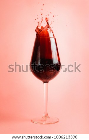 Red wine splashing in a glass, dynamic picture, selective focus.