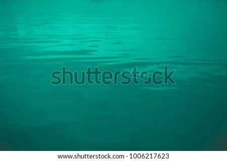 grean and blue water with cloud reflection and waves 