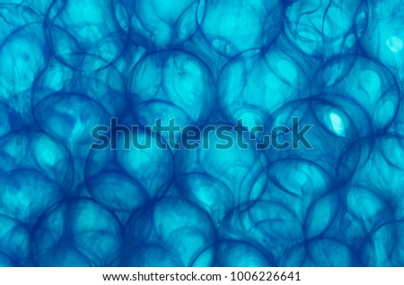 blue ink dissolves in water flowing through glazed spheres