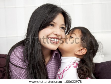 Little girl kissing her mommy in the home