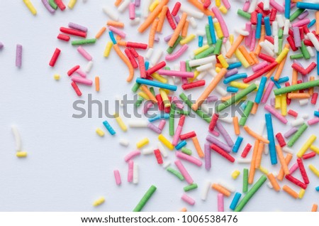 top view of multi-colored round sprinkles for a cake on a white background