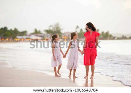 Beautiful mother and her adorable little daughter at beach