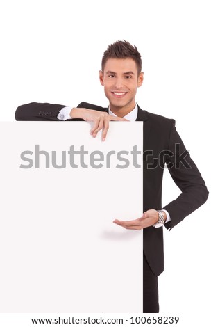 young business man showing you something on his blank board, over white background