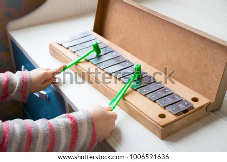 The child's hands playing xylophone.