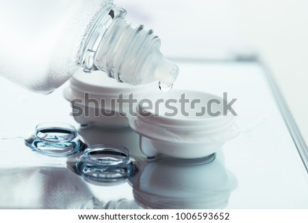 Bottle with lens solution and case on table Royalty-Free Stock Photo #1006593652