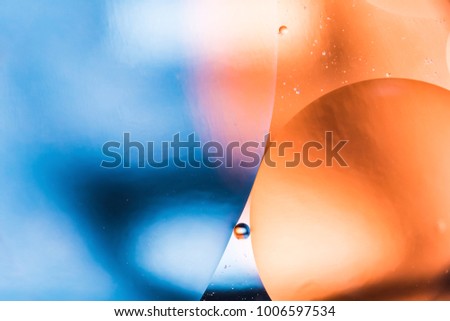 mixing water and oil, beautiful color abstract background based on blue and orange circles and ovals, macro abstraction