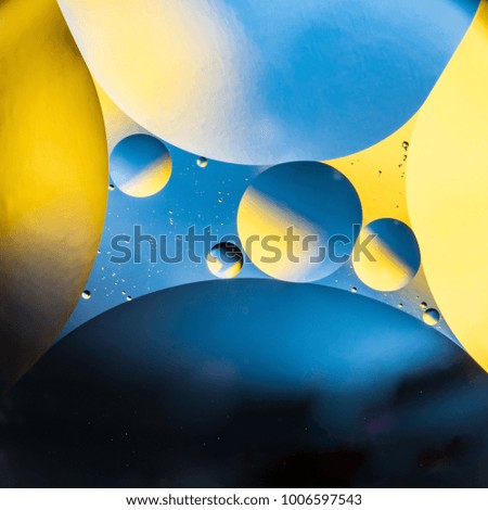 mixing water and oil, beautiful color abstract background based on yellow and blue circles and ovals, macro abstraction