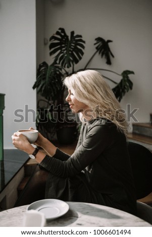 Beautiful blonde woman drinking coffee, happiness, smile, natural light