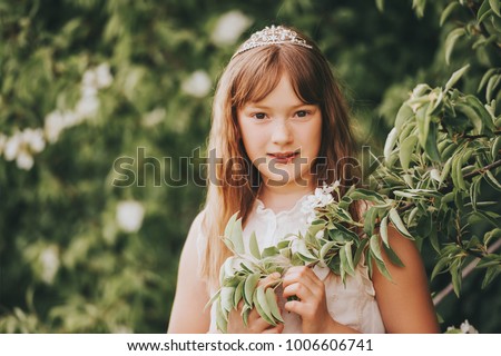 Spring close up portrait of adorable kid girl wearing a crown