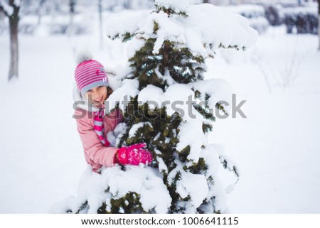 Cute little girl having fun outdoors on winter day.