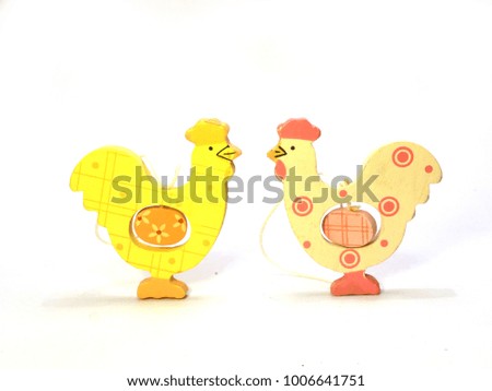 Two easter hen decorations with eggs in their stomachs in a line isolated against a white background (white / pink facing yellow)