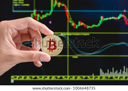 Cropped Image Of Hand Holding Bitcoin coin. Golden Bitcoin. Electronic money exchange concept. Physical version of Bitcoin virtual money. Conceptual composition for worldwide cryptocurrency