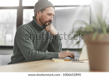 Creative graphic designer, keyboards information on laptop computer, generataes new ideas. Male copywriter works freelance, sits in cozy cabinet, sends email to customer via online application