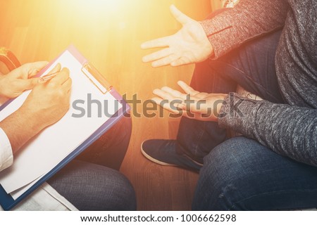 Psychologist listening to her patient and writing notes, mental health and counseling. Psychologist consulting and psychological therapy session concept, toned photo Royalty-Free Stock Photo #1006662598